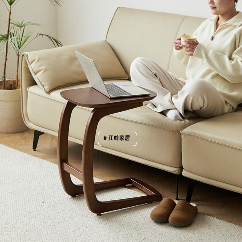 Solid wood C-shaped side table beside a sofa