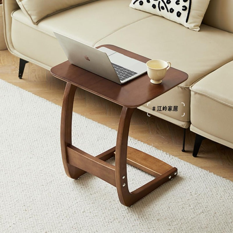 Solid wood C-shaped side table used with a laptop by a sofa