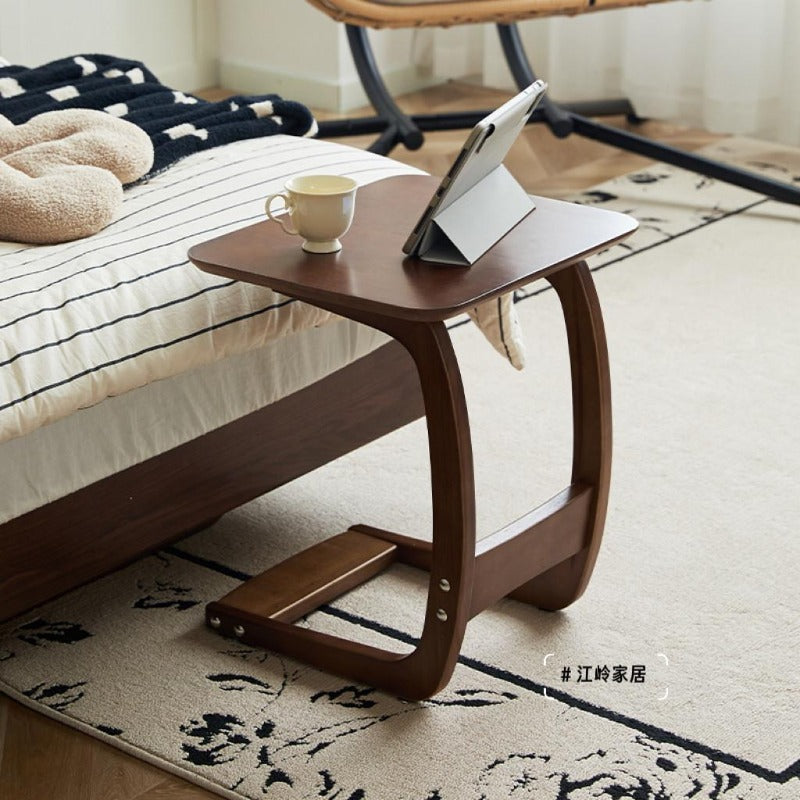 Walnut-finish solid wood C-shaped side table in a living room